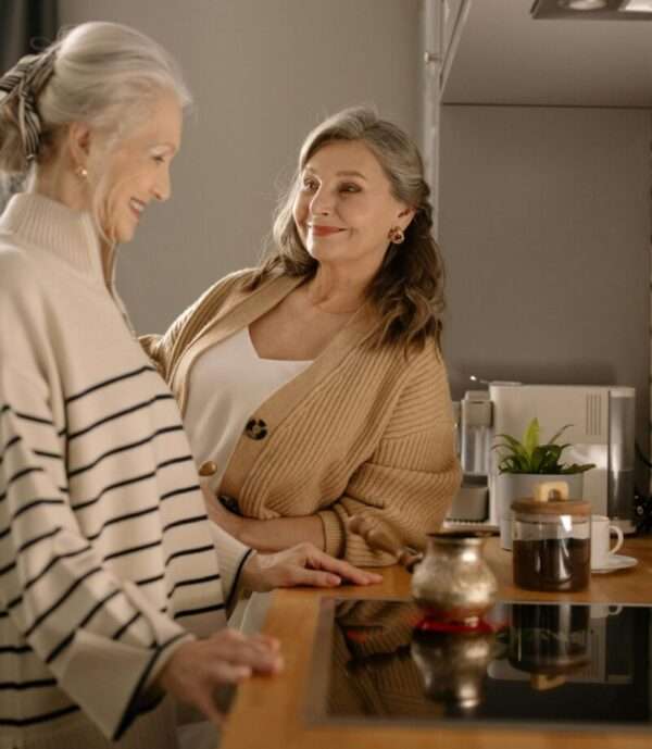 Two senior women in a cozy kitchen.
